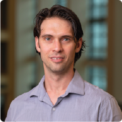 A color photo of a man smiling for a photo.