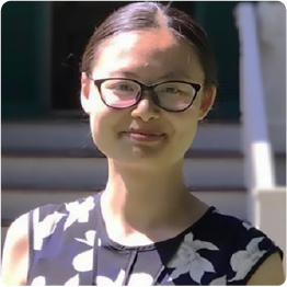 A color photo of a woman with glasses outside.