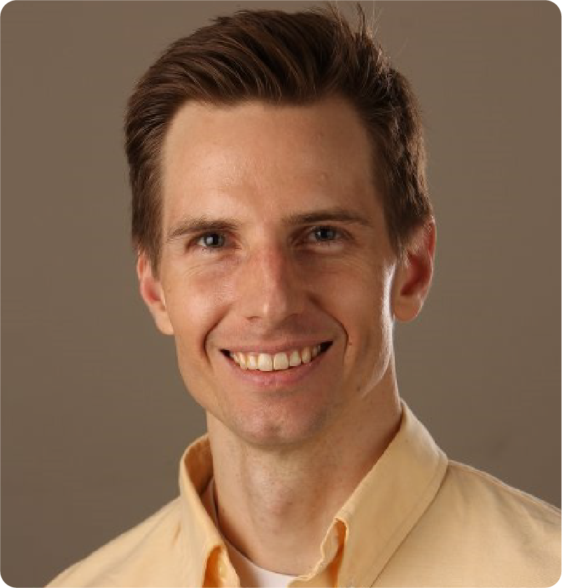 A color photo of a man smiling for a photo.