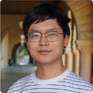 A color photo of a man with glasses smiling for a photo.