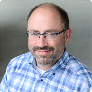 A color photo of a man smiling for a photo