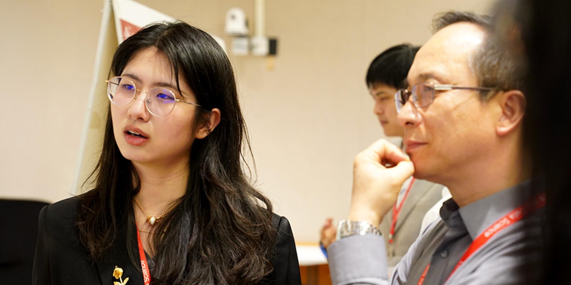 Two people listen and reflect during a research a presentation