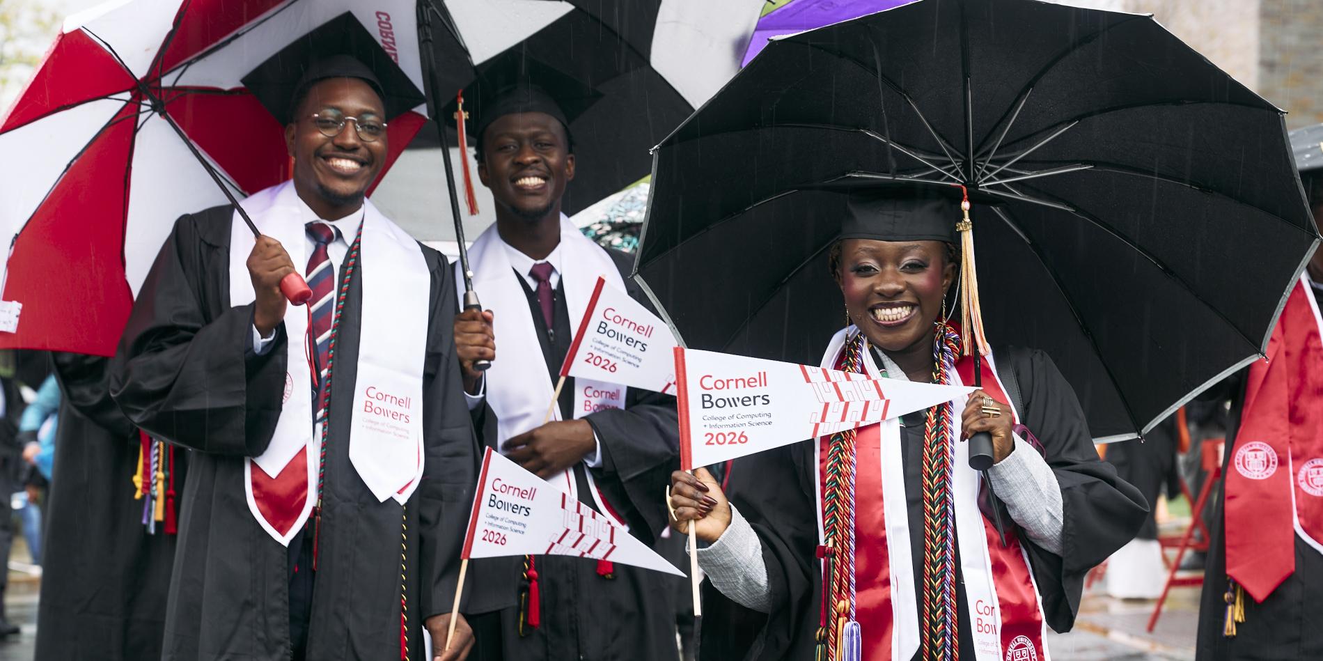 a group of black graduates smile under their umbrellas during the procession