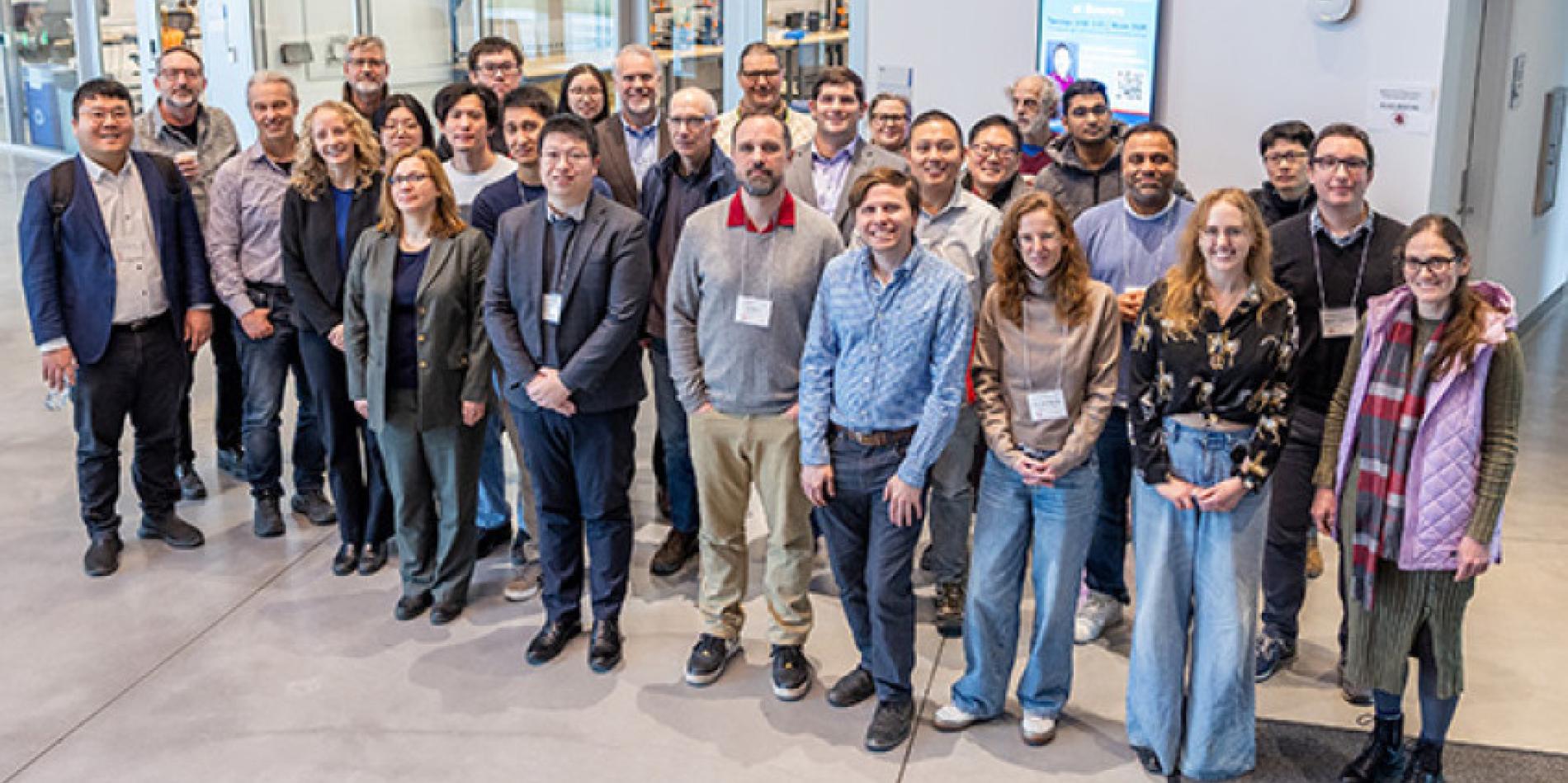 About 40 people stand outside of a classroom in an academic building
