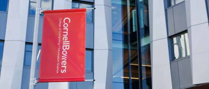 A color photo showing a red banner with the Cornell Bowers logo in white.