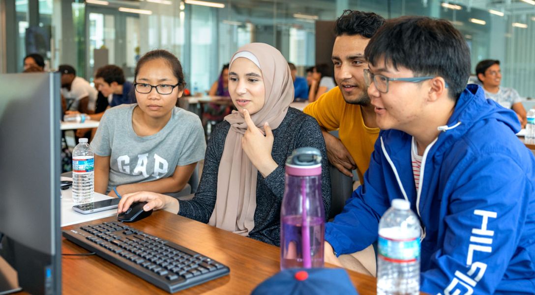 Group of students writing code on a computer