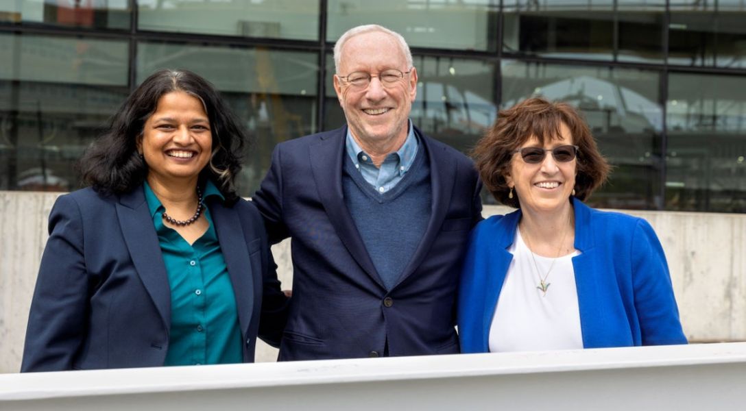 A color photo showing 3 people smiling for a photo