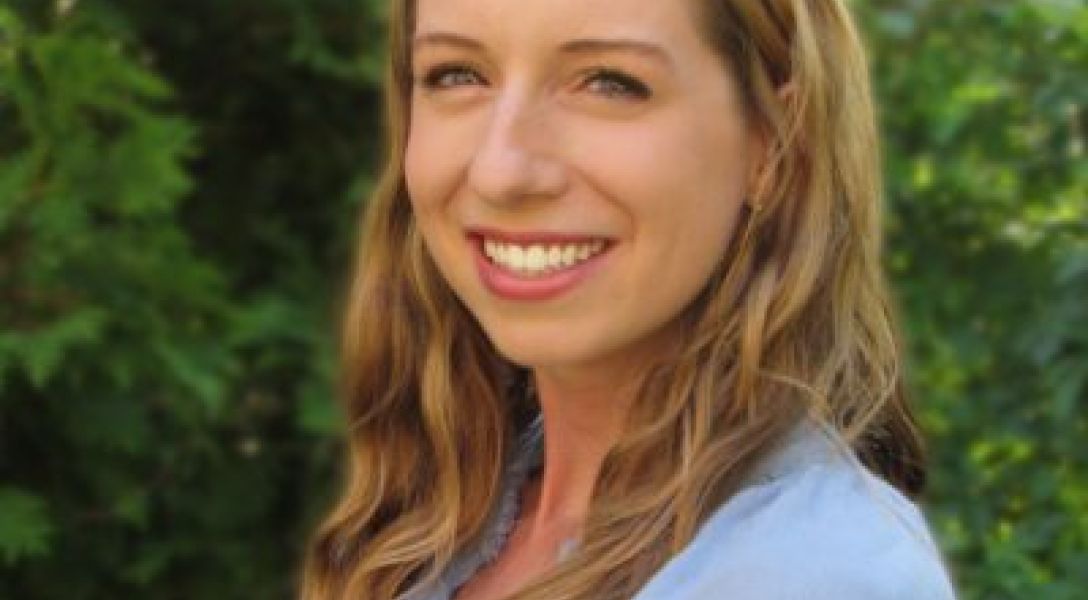 A color photo of a woman smiling for a photo