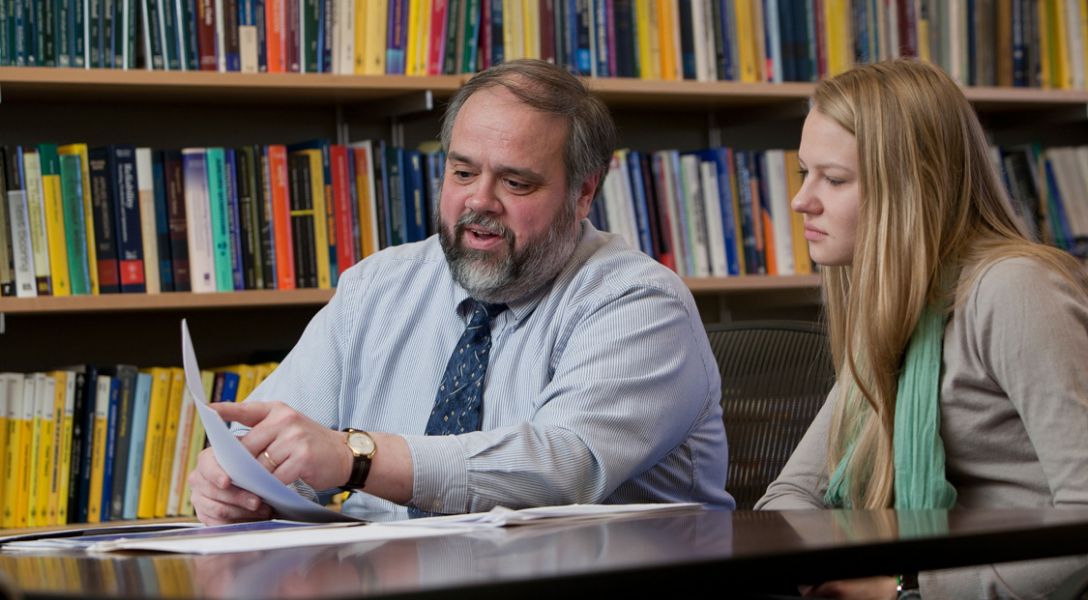 Marty Wells and a student look over papers