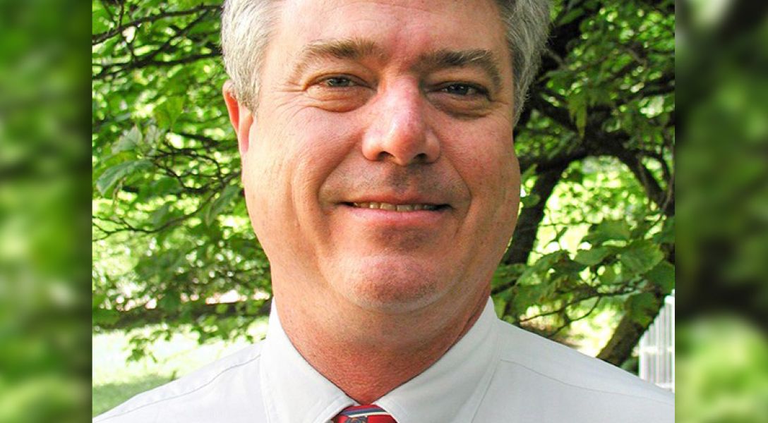 A color photo of a man smiling for a photo