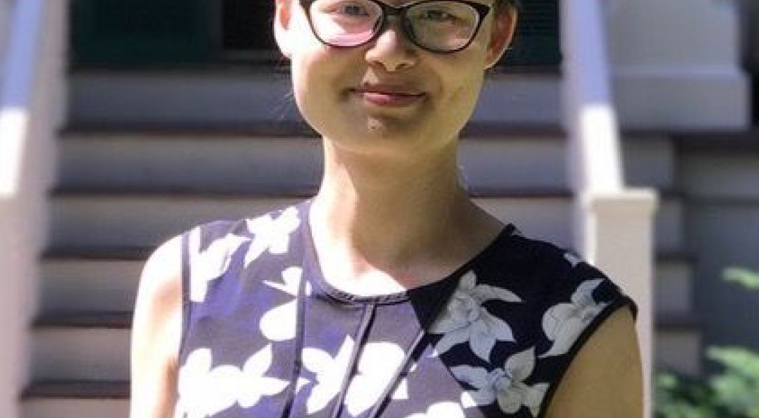 A color photo of a woman smiling for a photo