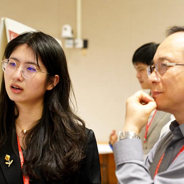 Two people listen and reflect during a research a presentation