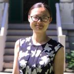 portrait of woman with hair pulled back and glasses, flower print dress