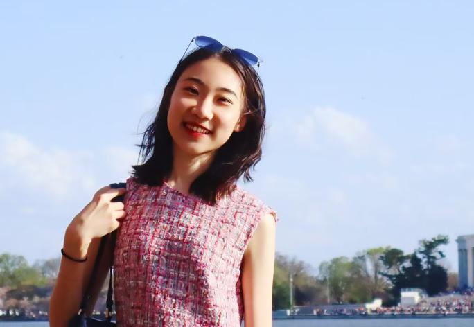 A color photo of a woman smiling for a photo.