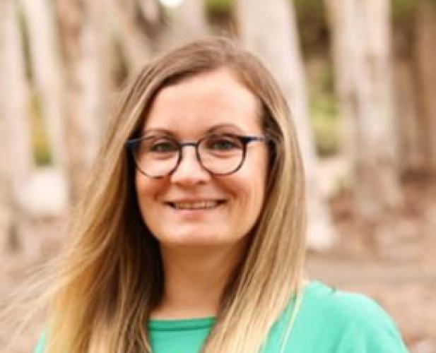 Color portrait of woman smiling at camera, long blonde hair, glasses
