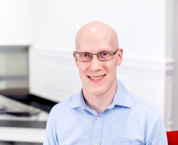 A color photo of Tyler Wilcox smiling for a photo