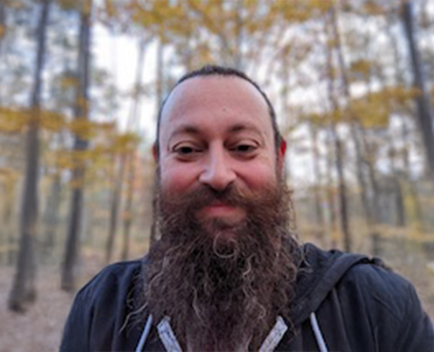 A color photo of Matt Thomas in the woods