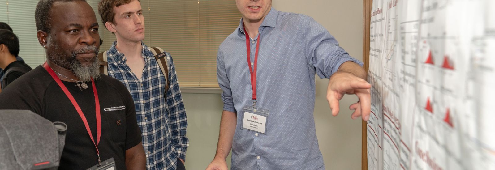 A student explains his research during a poster session held in conjunction with the 2018 Cornell Day of Statistics.