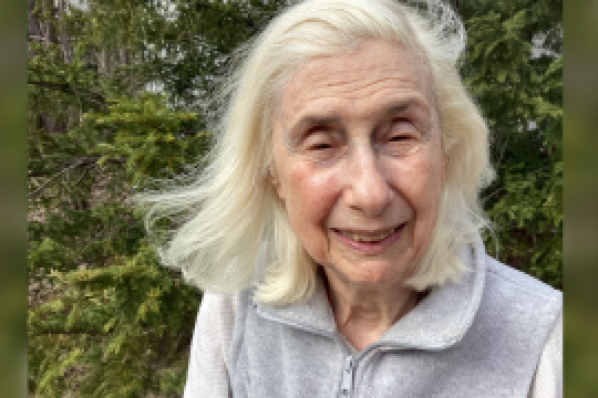 A color photo of a woman smiling for a photo