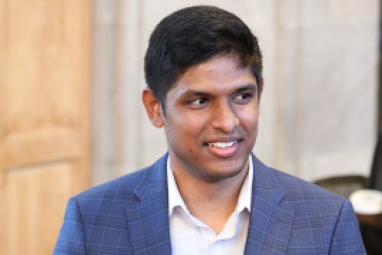 A color photo of a man smiling for a photo