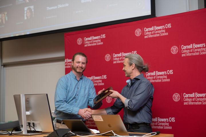 David Matteson, associate department chair and associate professor in statistics and data science, receives a Research Excellence Award from Thorsten Joachims, associate dean for research at Cornell Bowers CIS.