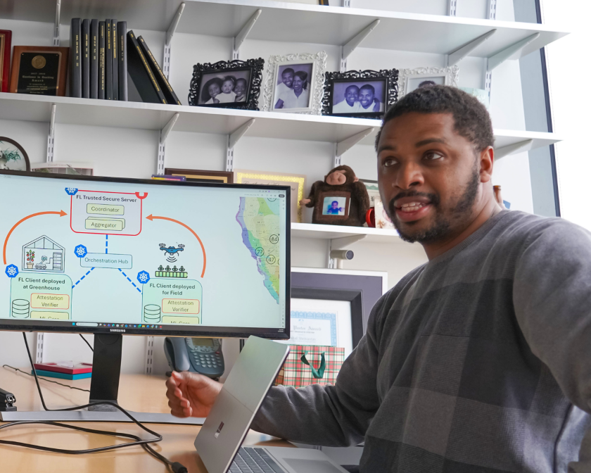 a man sits at a desk in front of a computer screen