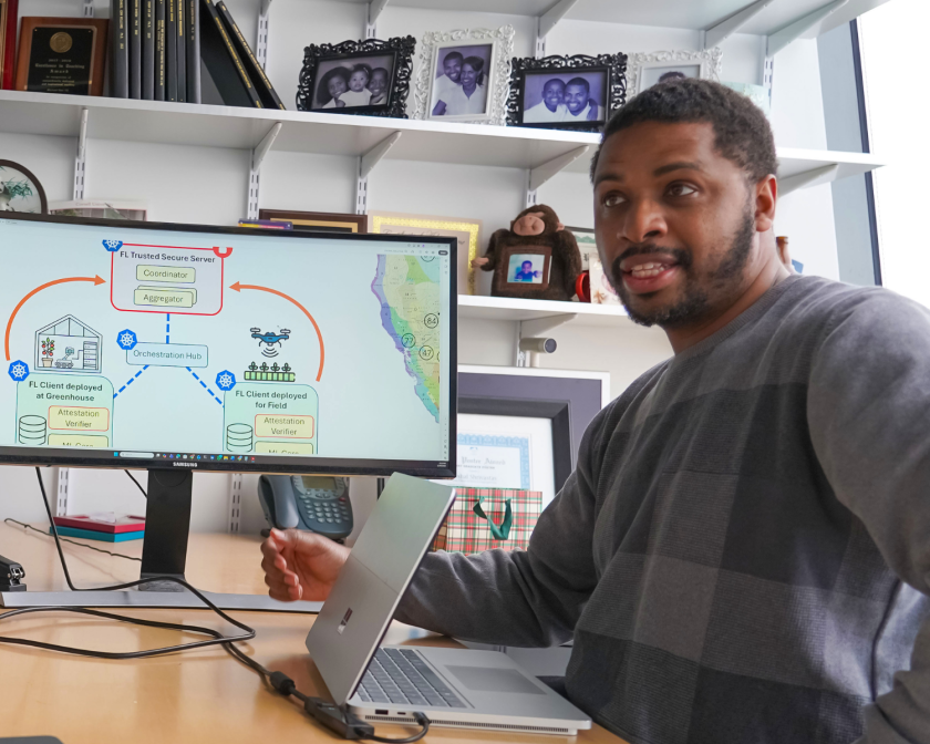 a man sits at a desk in front of a computer screen