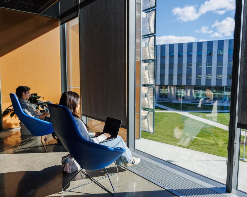A color photo showing students working by a window.