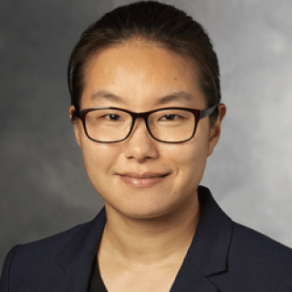 A color photo of a woman smiling for a photo