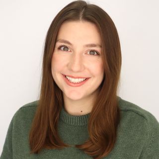 A color photo of a woman smiling for a photo