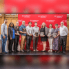 A color photo showing 10 people smiling for a photo after a recent awards ceremony