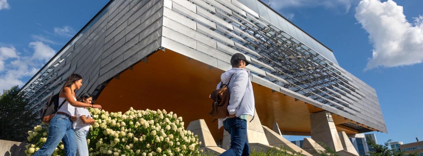 three students walk past Gates Gall